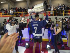 Tampa Bay Lightning Mathieu Joseph holds the Stanley cup high as he leaves the Fleury Arena in Montreal, Sunday, Aug. 15, 2021. Joseph, a Canadian on the Lightning's roster, is taking the Stanley cup for a tour in the area he grew up in and played as a youth.