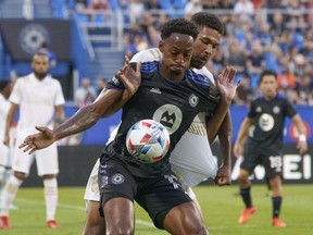 Atlanta United defender George Bello hangs on to CF Montréal forward Mason Toye during first-half action at Stade Saputo Wednesday night.