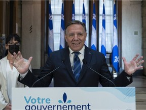 Quebec Premier François Legault gestures as he unveils his wish list to the leaders in the federal election, at his office in Quebec City, Thursday, Aug. 26, 2021. Quebec Treasury Board president Sonia LeBel, left, looks on.