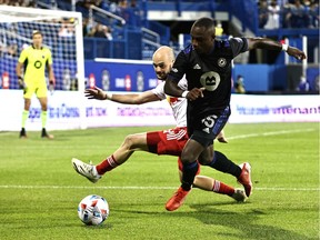 CF Montreal defender Zachary Brault-Guillard (15) and New York Red Bulls defender Andrew Gutman (5) battle for the ball during the second half at Stade Saputo. Mandatory Credit: Jean-Yves Ahern-USA TODAY Sports