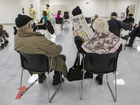 Two Montrealers sit in the waiting area after receiving COVID-19 vaccines at the Décarie Square clinic in Montreal on Monday, March 1, 2021.