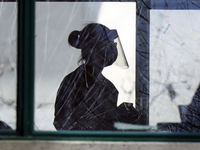 A worker in personal protective equipment walks through Residence Herron in Dorval on April 15, 2020.