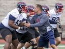 Montreal Alouettes assistant coach André Bolduc takes on offensive-lineman Jarvis Harrison during rookie camp in Montreal on May 15, 2019. 