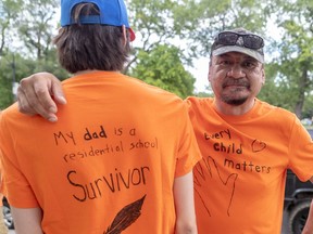 Dennis Saganash, right, and his son Christian were among the thousands who gathered in Montreal in July 2021 to honour Indigenous children, denounce genocide, and demand justice.