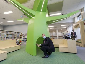 Dollard-des-Ormeaux Mayor Alex Bottausci checks out a reading nook in the base of a new tree structure in the children's section during a tour of the newly renovated municipal library.