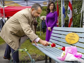 Elizabeth Rivera watches her husband Antoine Bittar place a rose on the commemorative bench that was unveiled in honour of their daughter Jessica Sarli-Rivera at Jacynthe Fyfe Park in the Pierrefonds-Roxboro borough on Wednesday. Jessica was killed when the car she was in, driven by a drunk driver, was involved in a collision in 2017.
