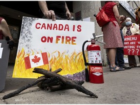 A group of climate change protesters stand in front of Marc Garneau's offices in Montreal on Thursday, July 29, 2021.