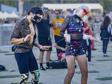 Louis Savoie and Kali Furlong dance to the beats of DJ Paul Kalkbrenner at the Île Soniq Redux electronic music festival at Parc Jean-Drapeau in Montreal on Friday, Sept. 24, 2021.