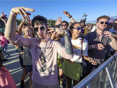 Anthony Pageau, left, Meriem Benzakour and Jasmin Petit dance to the beats of DJ Spencer Brown at the Île Soniq Redux electronic music festival at Parc Jean-Drapeau in Montreal on Friday, Sept. 24, 2021.