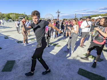 Sean Dinty dances to the beats of DJ Spencer Brown with a group of friends at the Île Soniq Redux electronic music festival at Parc Jean-Drapeau in Montreal on Friday, Sept. 24, 2021.