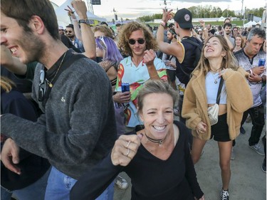 People dance to the beats of DJ Paul Kalkbrenner at the Île Soniq Redux electronic music festival at Parc Jean-Drapeau in Montreal on Friday, Sept. 24, 2021.