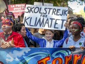 Greta Thunberg raises her climate strike sign at the Montreal march on Sept. 27, 2019.