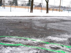 Green paint circles blood stains that mark the scene of a stabbing in the parking lot of a Laval park on Thursday, Jan. 2, 2020.