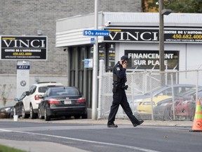 Police secure the area around the site of an overnight murder in Laval on Friday Oct. 12, 2018. Alessandro Vinci, 31, a sales manager at Automobiles Vinci, was killed. Frédérick Silva is charged with murder.