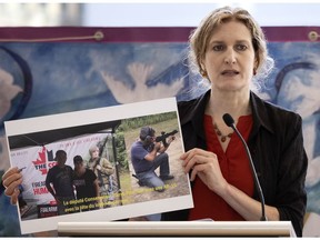 Heidi Rathjen, a member of the gun-control group PolySeSouvient and survivor of the 1989 Polytechnique massacre displays a picture of Conservative party candidate in the riding of Charlesbourg--Haute-Saint-Charles, Pierre-Paul Hus firing an assault rifle at a gun lobby sponsored event. Rathjen was speaking to the media at the Polytechnique in Montreal, on Thursday, September 9, 2021.