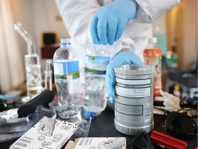 A police officer examines chemicals and equipment found in a methamphetamine manufacturing lab following a police raid on January 17, 2018 in Auckland, New Zealand.