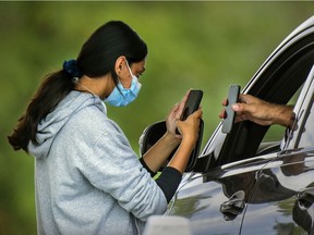 A nurse scans a client's information at the commercial drive-thru COVID-19 testing tent at Fairview Pointe Claire mall west of Montreal Sunday September 5, 2021.