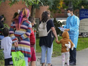 A health care worker greets people lining up outside a COVID testing centre on Park Ave. on Tuesday, Sept. 14, 2021.