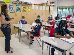 A Grade 3 teacher and students wear masks in class at a Lester B. Pearson School Board elementary school in the West Island on Thursday, Sept. 9, 2021.