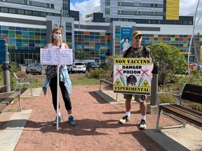 A small crowd gathered for a "silent vigil" outside the MUHC to protest against mandatory vaccination for health-care workers on Sept. 13, 2021.