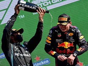Mercedes' second- place British driver Lewis Hamilton, left, and winner Red Bull's Dutch driver Max Verstappen, celebrate on the podium of the Zandvoort circuit after the Netherlands' Formula One Grand Prix in Zandvoort on Sunday, Sept. 5, 2021.