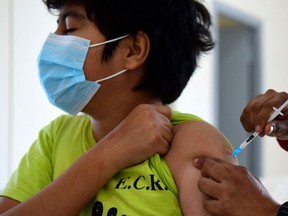 This file photo taken on July 23, 2021 shows a minor receiving a dose of the Pfizer-BioNTech vaccine against COVID-19 at a vaccination center in Asuncion, Paraguay. - Pfizer and BioNTech on Monday, September 20, 2021 said trial results showed their coronavirus vaccine was safe and produced a robust immune response in children aged five to 11, adding that they would seek regulatory approval shortly.