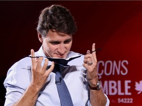 "It is not right to call an election within a mere two years, especially during a pandemic," Clifford Lincoln writes. But that is not what disturbs him most. Above: Liberal Leader Justin Trudeau puts on a mask during a campaign stop in Toronto.