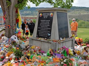 People visit a makeshift memorial on the grounds of the former Kamloops Indian Residential School.