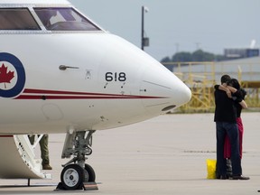 Michael Kovrig embraces his wife, Vina Nadjibulla, after arriving at Pearson International Airport in Toronto, on Sept. 25, 2021.