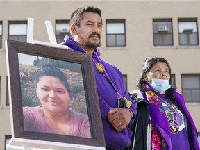 Carol Dube, husband of Joyce Echaquan, with her mother Danielle, stand next to a photo of his deceased wife during a memorial marking the first anniversary of the death of his wife in front of the hospital where she died in Joliette, on Tuesday, Sept. 28, 2021.