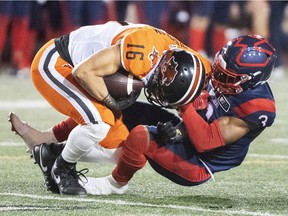 B.C. Lions' Bryan Burnham is pulled down by Montreal Alouettes' Patrick Levels during second half in Montreal on Spet. 18, 2021.