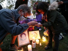 People light candles at a vigil on the first anniversary of the death of Joyce Echaquan on September 28, 2021 in Montreal.
