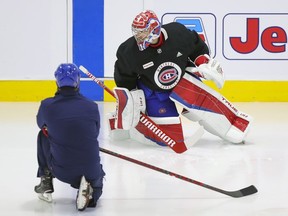 Montreal Canadiens goalie Carey Price does some exercises on the ice under the supervision of a member of the team's training staff at the Bell Sports Complex in Brossard on Sept. 16, 2021.