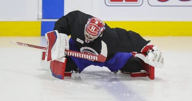 Montreal Canadiens goalie Carey Price stretches on the ice under the supervision of a member of the team's training staff at the Bell Sports Complex in Brossard on Thursday, Sept. 16, 2021.
