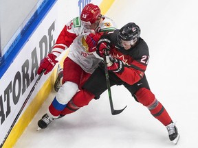 Canada's Kaiden Guhle (21) checks Russia's Vasili Podkolzin (19) during third period of World Junior Hockey Championship pre-competition action in Edmonton on Dec. 23, 2020.