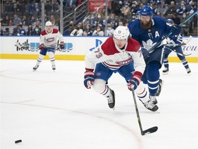 Maple Leafs defenceman Jake Muzzin (8) battles for the puck with Montreal Canadiens' Tyler Toffoli (73) during the first period at Scotiabank Arena in Toronto on Saturday, Sept. 25, 2021.