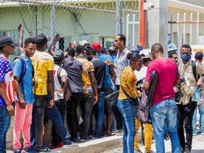 Haitian migrants who were flown out of Texas by U.S. authorities wait outside of Toussaint Louverture International Airport for processing by Haitian authorities, in Port-au-Prince, Haiti September 22, 2021.