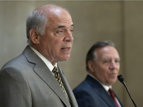 Quebec Economy and Innovation Minister Pierre Fitzgibbon responds to reporters questions as Quebec Premier Francois Legault, right, looks on during a news conference on Wednesday, September 1, 2021 at the legislature in Quebec City. Fitzgibbon returned to the cabinet of Legault after withdrawing in June because of ethics violations.