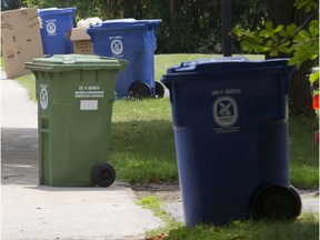 Bins for recyclable (blue) and compostable (green) waste wait to be picked up in Pointe-Claire