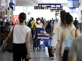 Passengers walk through the arrivals area at Montreal's Trudeau Airport on July 19, 2021