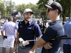 Canadiens' Jonathan Drouin, left, and Laurent Dauphin speak before the start of Montreal head coach Dominique Ducharme's charity golf tournament in Joliette on August 26, 2021.