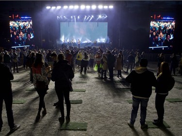 Fans watch rapper Odie from a distance on Day 1 of the Osheaga Get Together at Parc Jean-Drapeau on Friday, Oct. 1, 2021. The site was divided into around a dozen “quais,” each holding up to 500 people, dotted with small, equidistant rectangles of turf to keep fans at a safe distance.