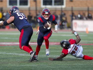 Montreal Alouettes quarterback Matthew Shiltz gets a block from offensive lineman Landon Rice as he runs for a first down past a diving Avery Williams during game-winning drive against the Ottawa Redblacks in Canadian Football League game in Montreal Monday October 11, 2021.