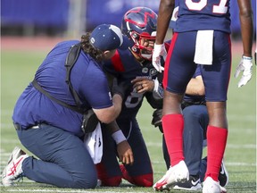 Montreal Alouettes quarterback Vernon Adams Jr. winces in pain as he's helped to his feet with an injury during the second half against the Ottawa Redblacks in Montreal on Oct. 11, 2021.
