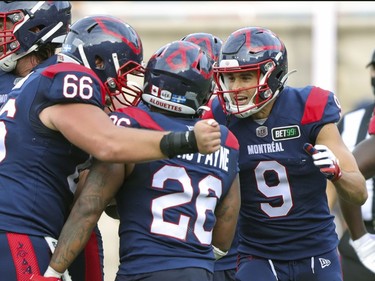 Montreal Alouettes Jake Wieneke, right, and David Brown celebrate with running back Cameron Artis-Payne after his game-winning touchdown in the last minute of Canadian Football League game against the Ottawa Redblacks in Montreal Monday October 11, 2021.