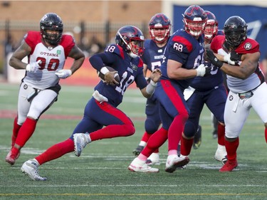 Montreal Alouettes quarterback Matthew Shiltz hits hole opened by offensive lineman David Foucault (68) as he runs for a first down during game-winning drive against the Ottawa Redblacks in Canadian Football League game in Montreal Monday October 11, 2021.