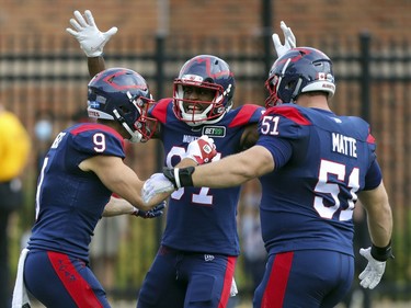Montreal Alouettes Jake Weineke, left, celebrates a first half touchdown against the Ottawa Redblacks with team-mates Eugene Lewis and Kristian Matte during Canadian Football League game in Montreal Monday October 11, 2021.