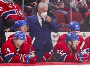 Canadiens head coach Dominique Ducharme adjusts his mask while standing behind Nick Suzuki, from left, Tyler Toffoli, Jonathan Drouin and Christian Dvorak during the third period of Tuesday night's 5-0 loss to the Sharks at the Bell Centre.
