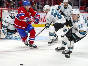 Montreal Canadiens' Nick Suzuki chases puck against San Jose Sharks' Logan Couture, Jacob Middleton and Jonathan Dahlen during first period in Montreal on Oct. 19, 2021.