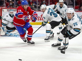 Montreal Canadiens' Nick Suzuki chases after the puck against San Jose Sharks' Logan Couture, Jacob Middleton and Jonathan Dahlen during first period in Montreal on Oct. 19, 2021.